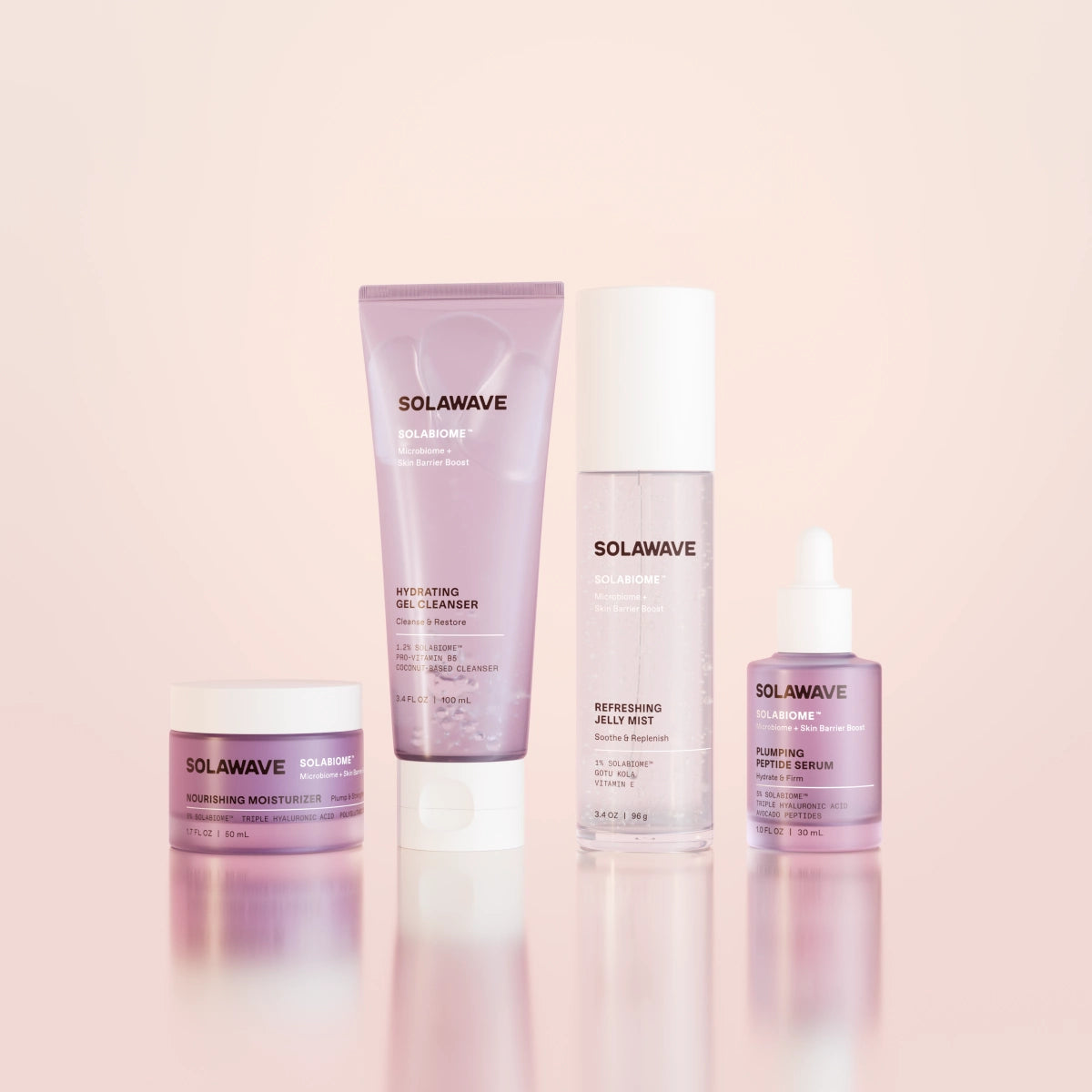 The Solabiome Glowing Skin Starter Kit by SolaWave features four skincare products with probiotics: a moisturizer jar, hydrating gel cleanser tube, jelly mist bottle, and radiance serum dropper. They are presented in chic purple packaging against a soft pink backdrop.