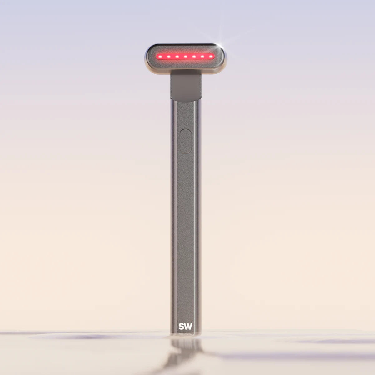 The charcoal-colored 4-in-1 Radiant Renewal Skincare Wand by SolaWave stands upright against a gradient background. It has a narrow head with glowing red lights for therapy, a button on the handle, and SW engraved at the base. Ideal for wrinkles, the background shifts from blue to beige.